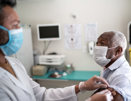 A man in a mask getting a vaccine.
